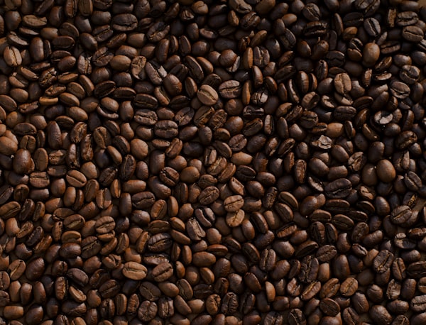 Roasted dark coffee beans spilling from canvas bag